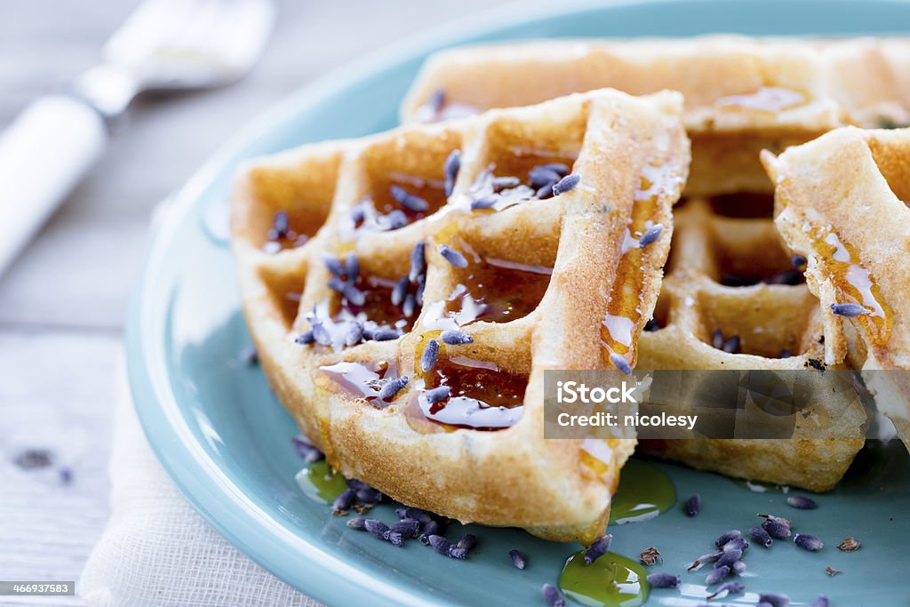 Waffles with Honey and Lavender Waffles on a blue plate topped with honey and lavender. Triangle Shape Stock Photo