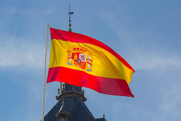 istock Spanish flag waving in the wind against a blue sky 466937727