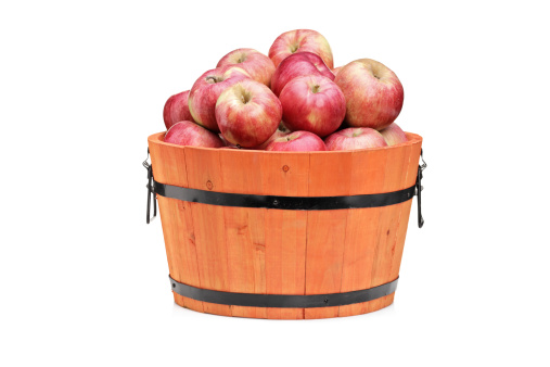 Studio shot of red apples in a wooden barrel isolated on white background