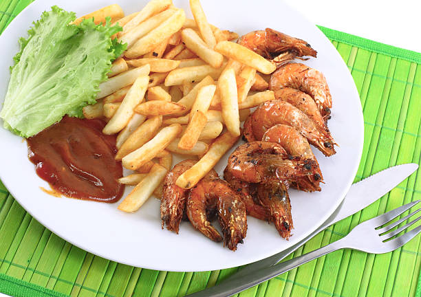 Deep-fried potatoes with fry shrimps and lettuce. Isolated over white background