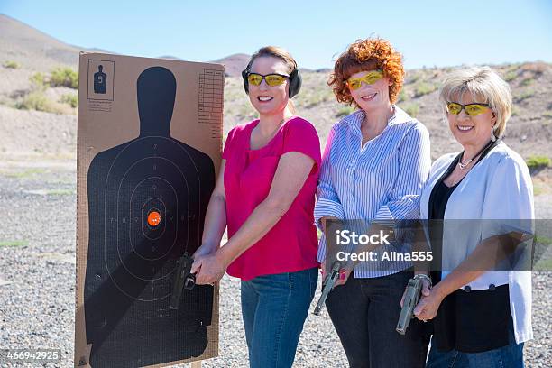 Três Mulheres A Pé Por Um Alvo Ao Ar Livre Com Seus Handguns - Fotografias de stock e mais imagens de Arma de Fogo