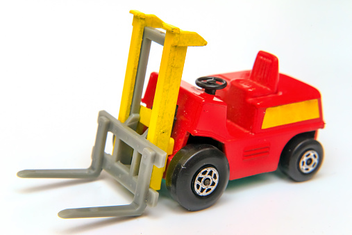 Red and yellow industrial fork lift loader truck toy isolated on white