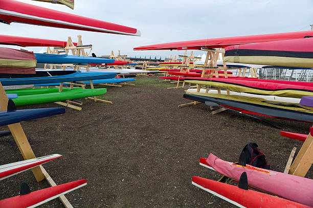 Variety of kayaks stored on the stands at the outdoor storage.
