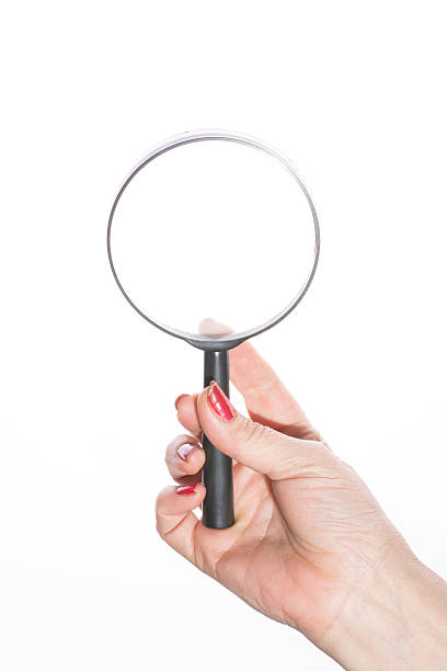 istock Female hand holding magnifying glass on a white background 466953830