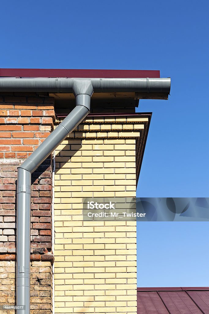 Gutter and brick wall Newly installed modern gutter and pipe Architectural Cornice Stock Photo