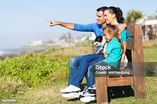 Photo libre de droit de Famille Assise Sur Le Banc Sur La Plage banque d'images et plus d'images libres de droit de Adulte - Adulte, Amour, Animaux de compagnie