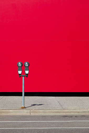 Coin operated parking meter with red background
