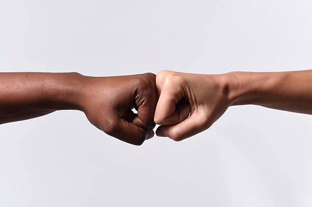 istock black African American race hand touching knuckles with white Caucasian 466958130