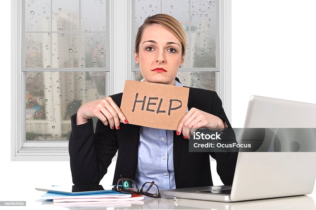 young stressed businesswoman holding help sign overworked at office computer young attractive frustrated businesswoman holding help message overworked at office computer, exhausted, desperate under pressure and stress with rainy sad window view 2015 Stock Photo