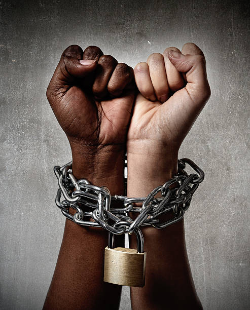 White and Afro-American hands locked together by a chain