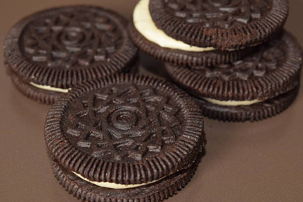 Chocolate cookies with cream filling on a brown plate.