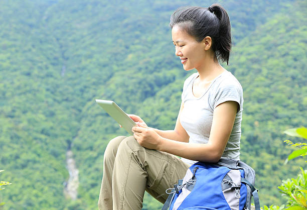 randonnée jeune femme avec tablette numérique sommet de la montagne - hiking young women outdoors t shirt photos et images de collection