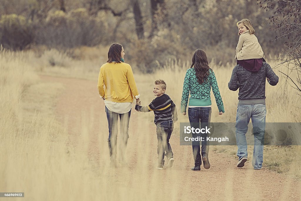 Family Walking Together Image of a young family walking together in a park interacting with each other. 4-5 Years Stock Photo