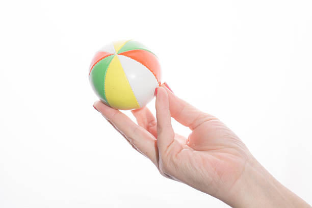 istock female hand holding colored juggling balls on a white background 466970130