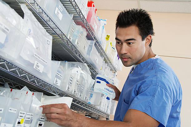 Medical Staff working Male nurse standing by shelves with medical supply, low angle view medical supplies stock pictures, royalty-free photos & images