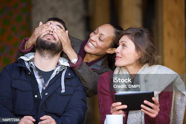 Woman Surprising Her Friends Upon Arrival At An Outdoor Cafe Stock Photo - Download Image Now