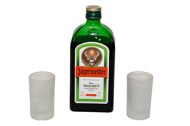 Jagermeister bottle with shot glasses stock photo