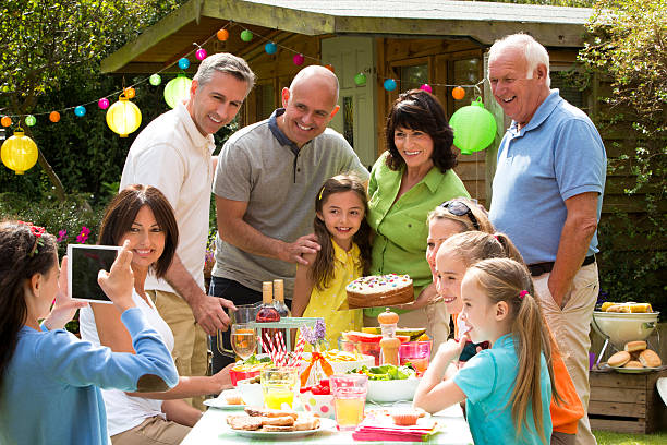 Birthday Barbecue A happy three generation family enjoy a summer barbecue in their garden together to celebrate a birthday. happy birthday cousin images stock pictures, royalty-free photos & images