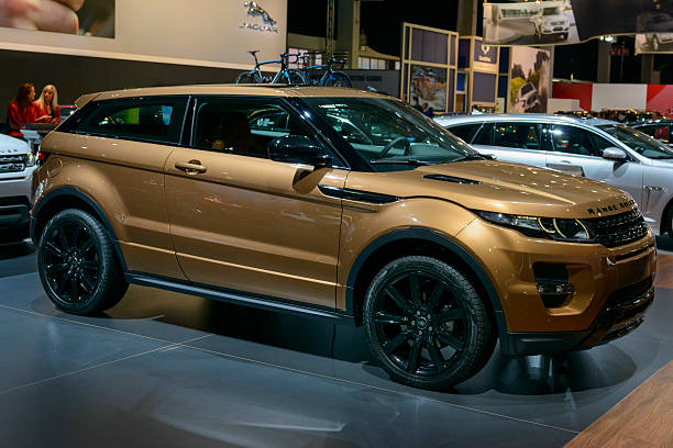 Range Rover Evoque Brussels, Belgium - January 14, 2014: Bronze Range Rover Evoque compact SUV on display at the 2014 Brussels motor show. Two girls are sitting behind a desk in the background. evoque stock pictures, royalty-free photos & images