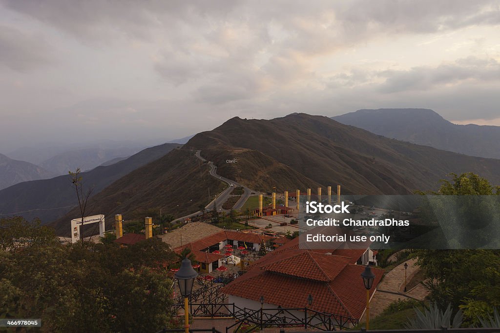 Colombia - Chicamocha National Park, Santander at sunset. Chicamocha, Colombia - January 14, 2014: Looking from a higher elevation over some Buildings in the Parque Nacional del Chicamocha or in English, the Chicamocha National Park, towards the main Entrance and car park.  In the background are the Andes mountains and the road from Bucaramanga to San Gil.  The sun has almost set; the elevation here is about 1500 metres above sea level. Andes Stock Photo