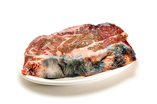 Spoiled Steak Raw spoiled steak on white. rotting stock pictures, royalty-free photos & images