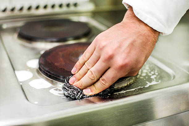 Cleaning stove Man cleaning stove with scouring pad cleaning stove domestic kitchen human hand stock pictures, royalty-free photos & images