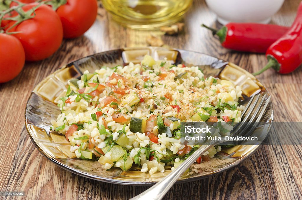 salad with bulgur, zucchini, tomatoes and parsley salad with bulgur, zucchini, tomatoes and parsley on a wooden table Bulgur Wheat Stock Photo