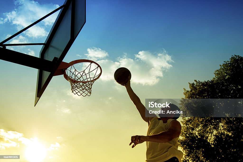 Basketball player silhouette at sunset Basketball - Sport Stock Photo