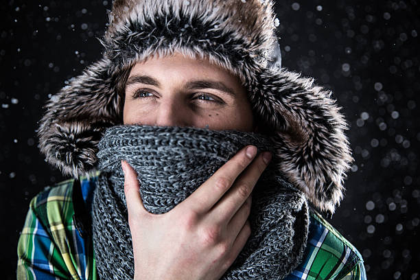 istock pensive man in hat and scarf with snow 466987776