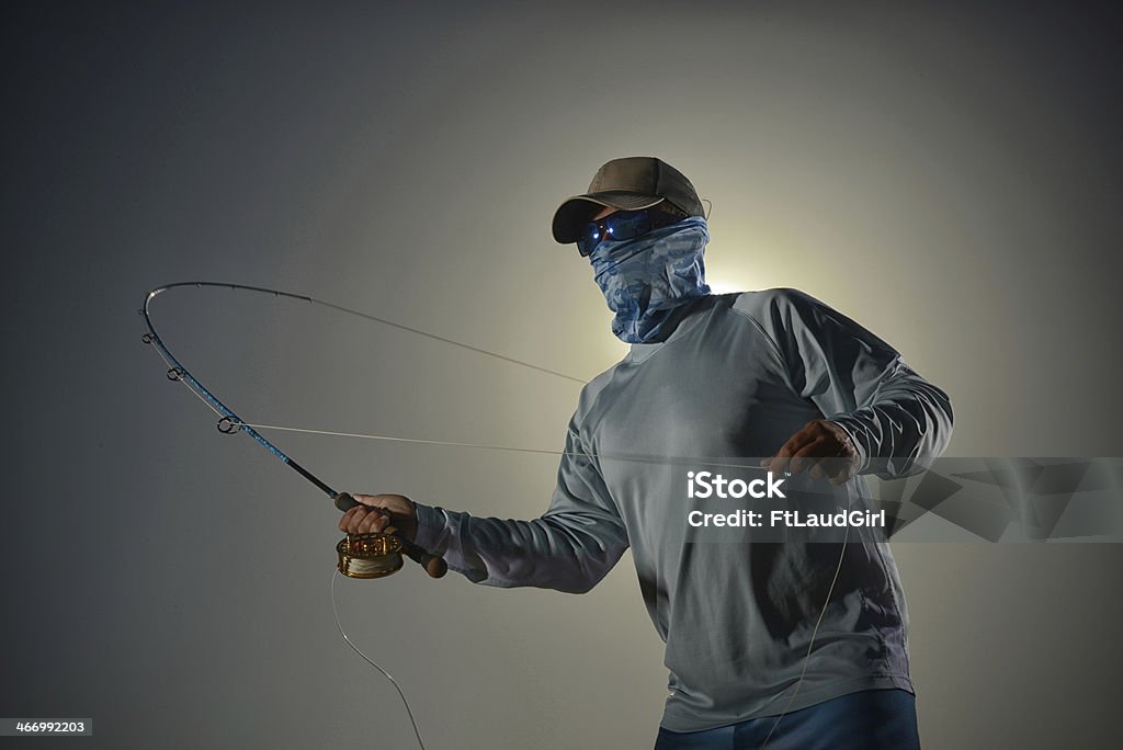 man fishing guy casting while fishing against a plain background Fishing Stock Photo