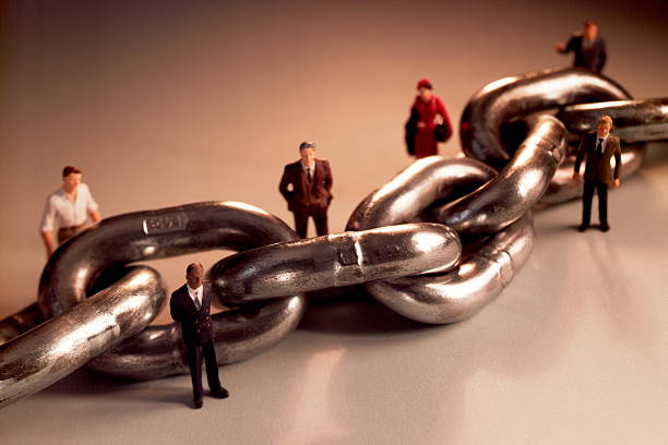 People Standing Along Large Chain stock photo