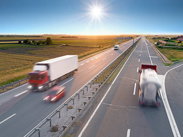 istock Trucks and car on the freeway at sunrise 466994566