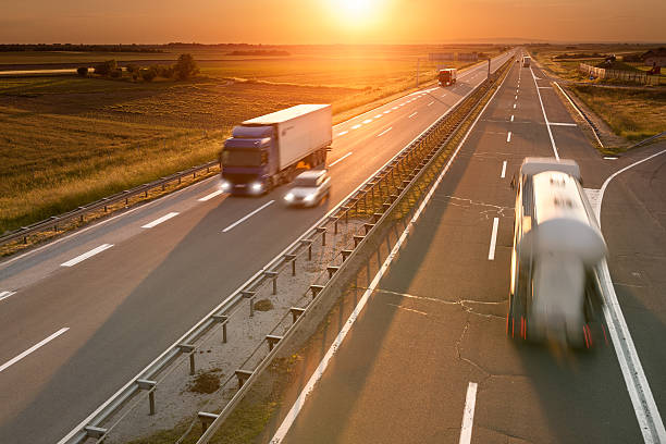 istock Trucks and car on the highway at sunset 466994568
