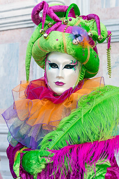 зеленый и фиолетовый маска в сан-zacharias площадь, венеция, италия, европа - venice italy editorial mardi gras performer стоковые фото и изображения