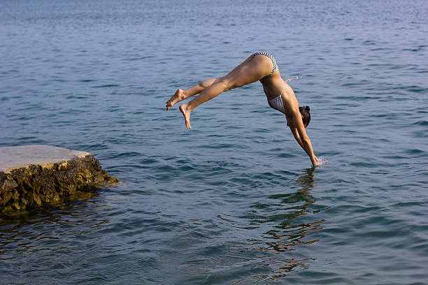 istock Female jumping into the water 466996519