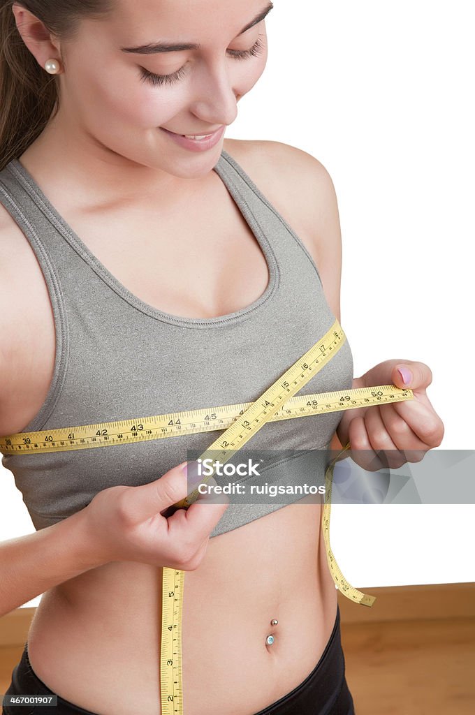 Woman Measuring Up Her Chest Sporty woman measuring up her chest, isolated in white Adult Stock Photo