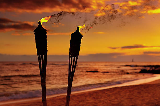 Tiki Lamps on the Beach of Hawaii Subject: Tiki torch lamp in a Hawaiian vacation resort against the sunset on a beach. tiki torch stock pictures, royalty-free photos & images