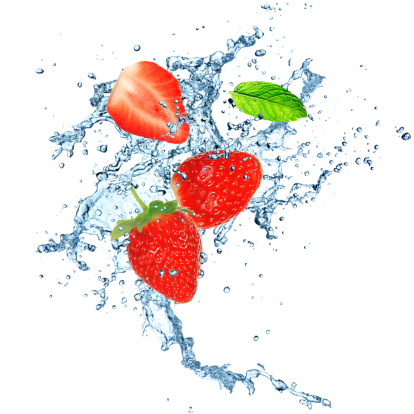 Strawberry in water splash over white