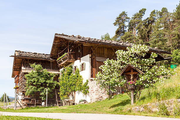 South Tyrol Ritten, Italy - May 29, 2011: wayside cross before traditional south tyrolean mountain farmhouse in spring.