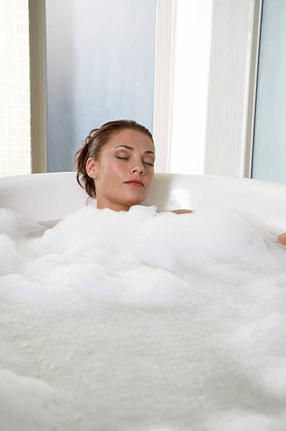 istock Young woman lying in bathtub 467003576
