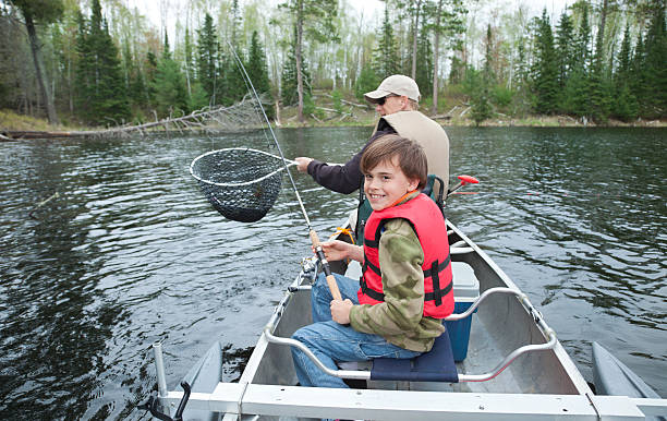 istock Young fisherman in a canoe smiles seeing walleye netted 467005055