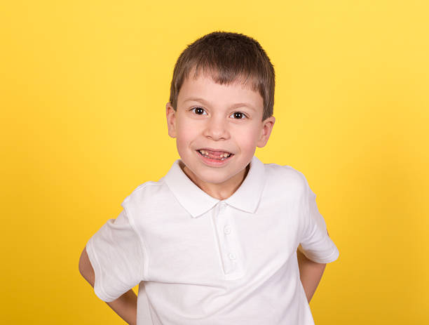 istock boy portrait in white shirt on yellow 467006419