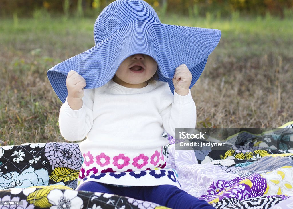 Cueros de chica con sombrero tocando azul grande "peek un boo" - Foto de stock de Aire libre libre de derechos