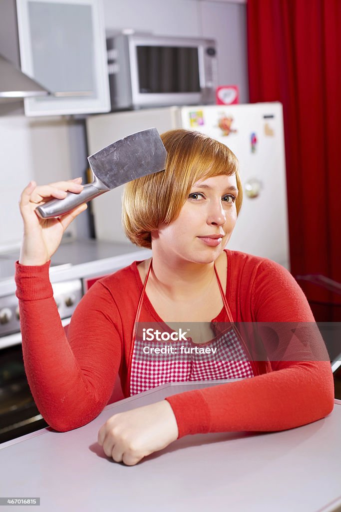 Hübsche kunstvolle Hausfrau mit Messer im kitchen - Lizenzfrei Attraktive Frau Stock-Foto