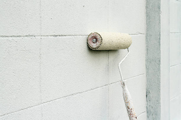 istock White paint roller withleaning against wall outside 467017693