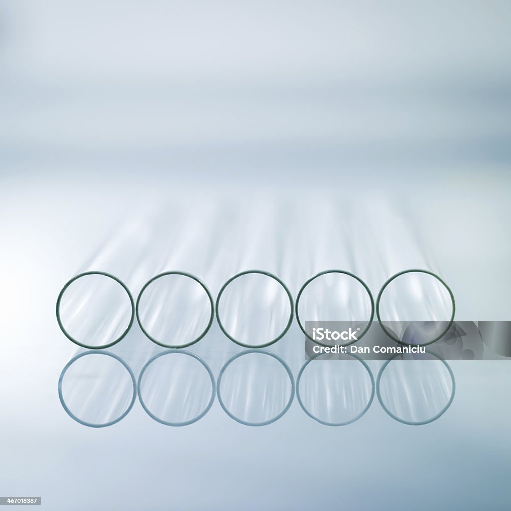 Horizontal empty glass test tubes A close-up of five horizontal medical test tubes on a light blue gradient background Antiseptic Stock Photo