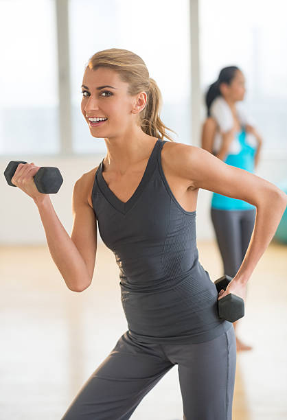 istock Happy Woman Lifting Dumbbell At Gym 467018687