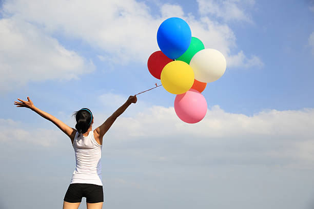 istock cheering woman with colorful balloons 467019910