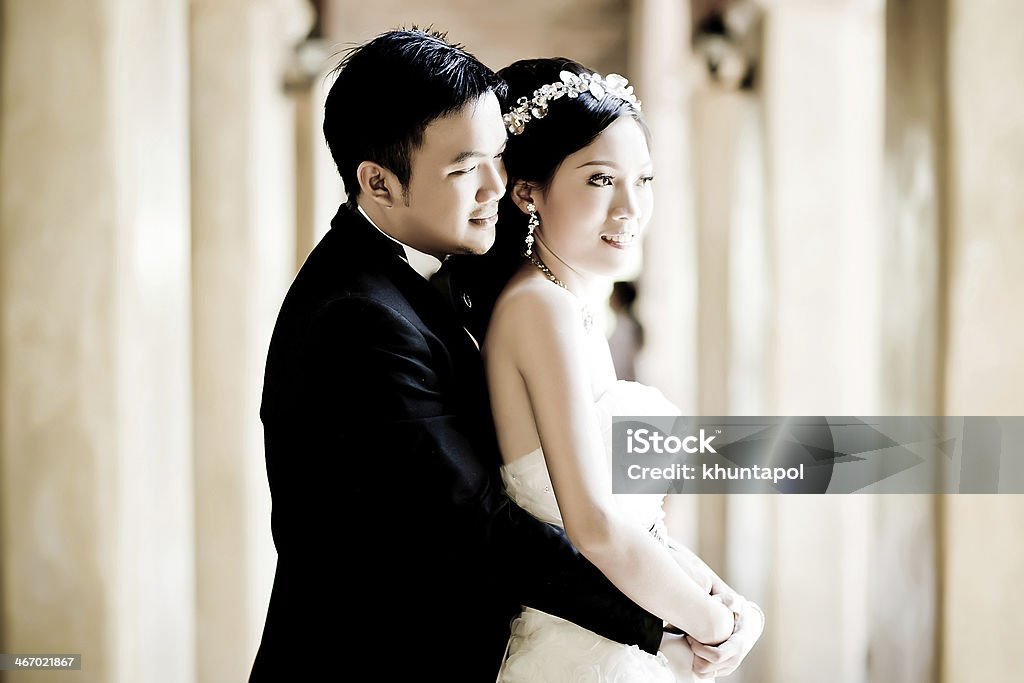 An Asian couple in wedding attire smile and embrace Closed up wedding couple show concept of love Multiracial Group Stock Photo