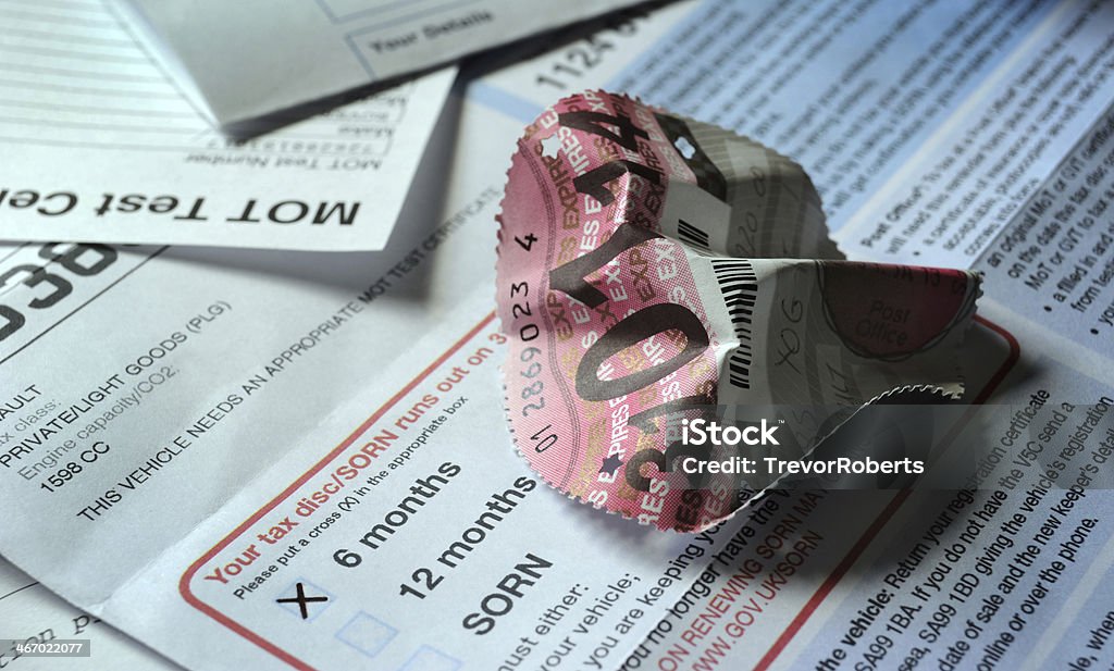 CRUMPLED BRITISH CAR ROAD TAX DISC WITH DOCUMENTS A BRITISH CAR TAX DISC CRUMPLED CREASED WITH  ROAD TAX APPLICATION FROM AND OTHER DOCUMENTS Tax Stock Photo